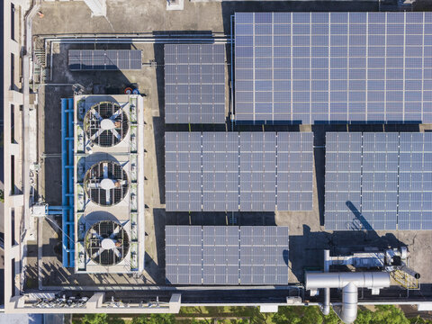 Aerial view of solar panels and industrial cooling fans on a building rooftop in Taiwan.