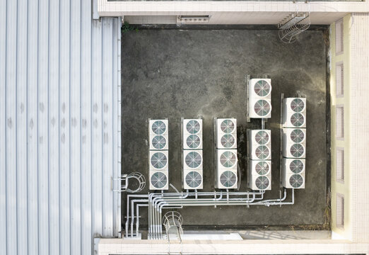 Aerial view of industrial air conditioning units and metal pipes on a building rooftop in Taiwan.