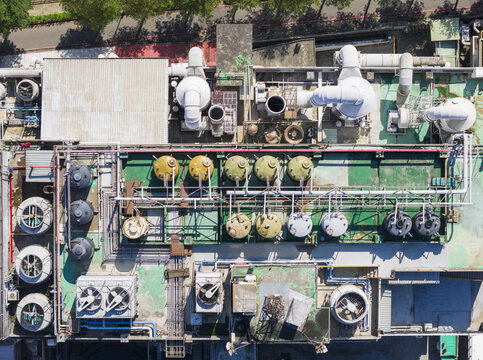 Aerial view of a PCB factory rooftop with industrial ventilation pipes, storage tanks, and cooling units in Taiwan.