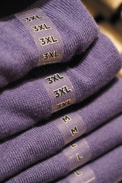 Shirts stacked in purple color with size labels displayed