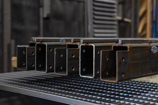 Alignement de profil&eacute;s m&eacute;talliques en acier sur cales en bois dans un atelier de fabrication pour la pr&eacute;paration de charpentes industrielles.