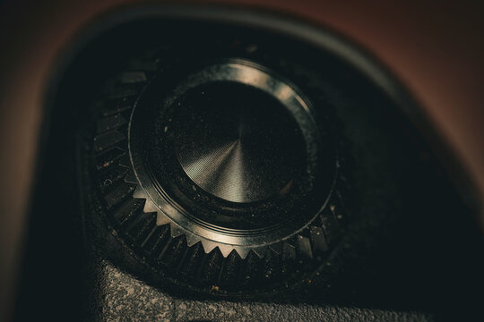 Macro closeup of camera shutter button with textured dial and gear detail showing precision photography control and metal surface