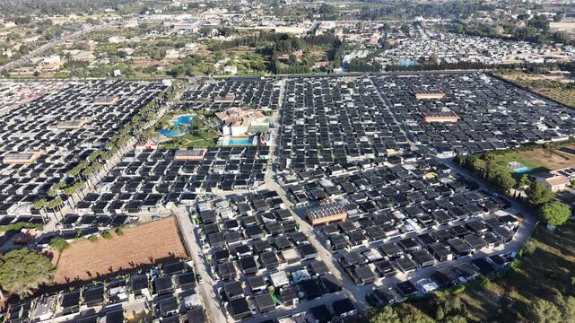 High-angle drone shot showing dense residential housing and holiday resorts in Benidorm with the iconic Puig Campana mountain in the background.