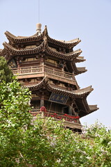 Fototapeta premium The crescent moon-shaped spring cradled by golden dunes, with the elegant Yuequan Pavilion standing guard – a miraculous oasis in China's desert landscape.