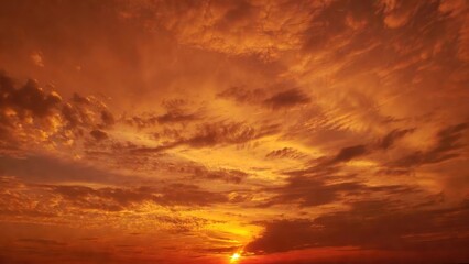 Fototapeta premium Sun setting behind dramatic cloud cover over horizon