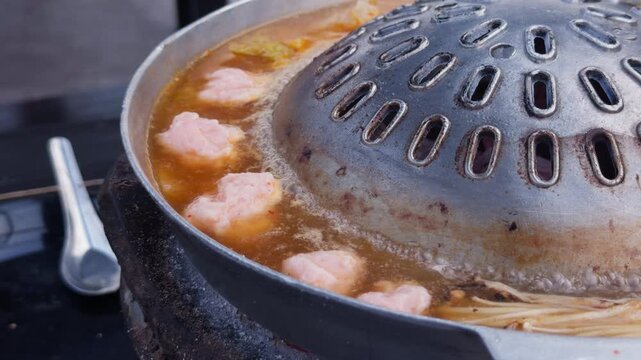 Thai Mookata Hot Pot Simmering with Broth and Ingredients, Close-Up