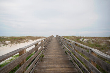 Fototapeta premium Wooden boardwalk leading through dunes to Gulf Shores beach