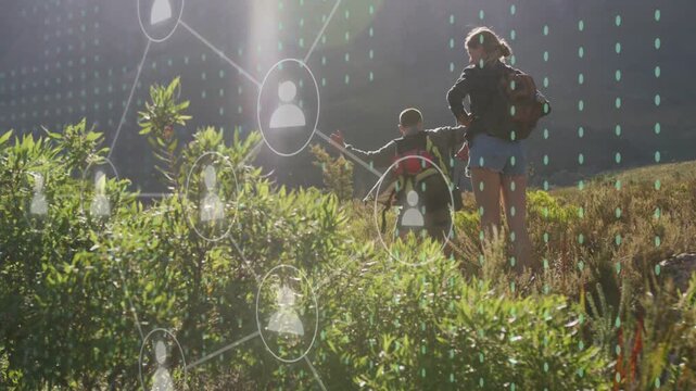 Two hikers climbing ridge, sunbeam causing tech icons filling frame with one pointing forward