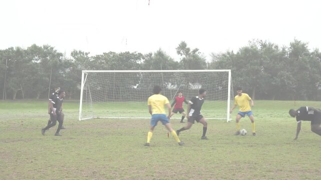 Soccer attacker dribbling into box, drawing slide tackle, seeking shot, defender clearing ball wide