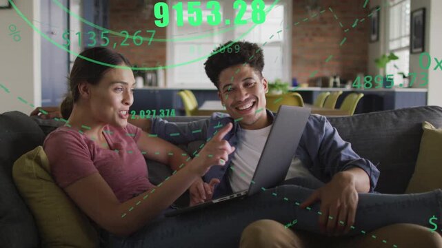 Left person typing on laptop on sofa checking finance while green charts floating over couple