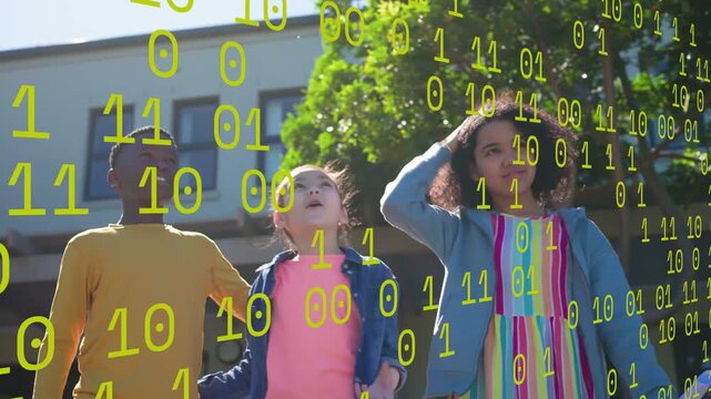 3 students lifting caps, stepping forward for graduation while binary overlay moving across school