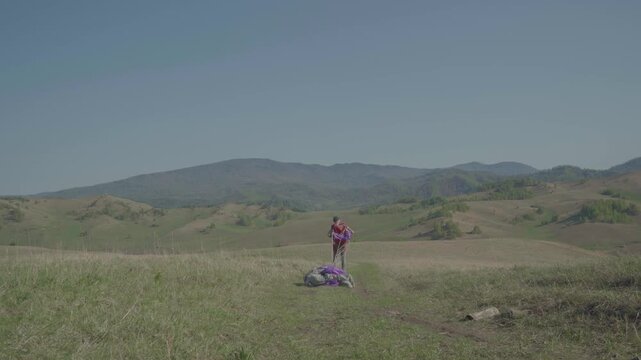 Skydiver after landing in wilderness area. Extreme sports, adrenaline, risk, challenges.