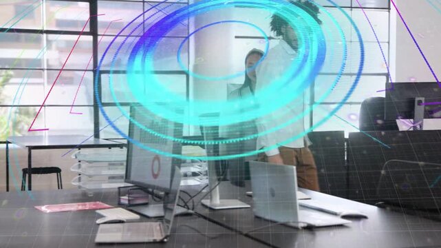 Man and woman walking into tech office entry causing circle overlay over laptop while checking data