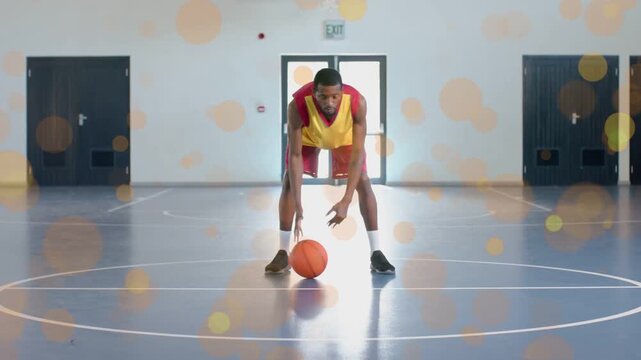 Vertical video: Entering gym player yellow jersey dribbling low then lifting basketball practicing