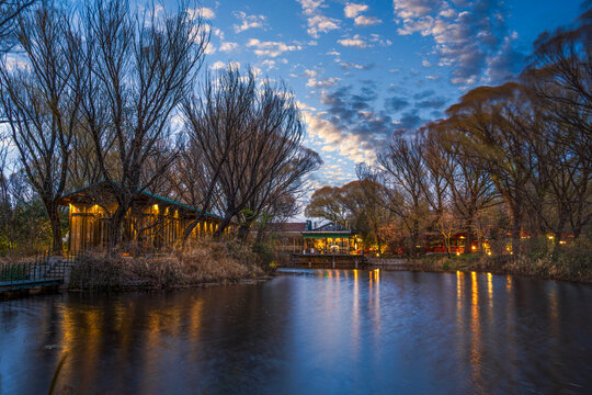 Blue hour lakeside landscape with warm glowing light reflections