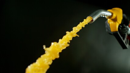 Naklejka premium Close-up of Gasoline Spurting from the Gas Pump Nozzle