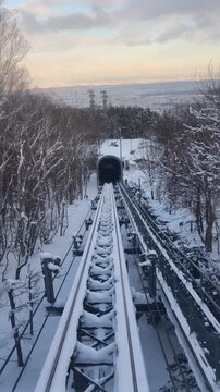 Winter Funicular Railway Descending Snowy Mountain at Sunset