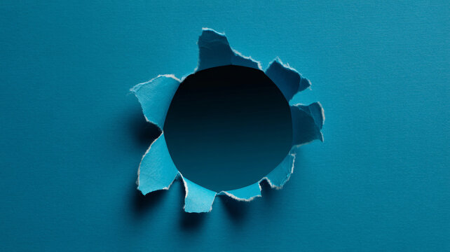 A torn hole in a blue background with jagged edges and shadows