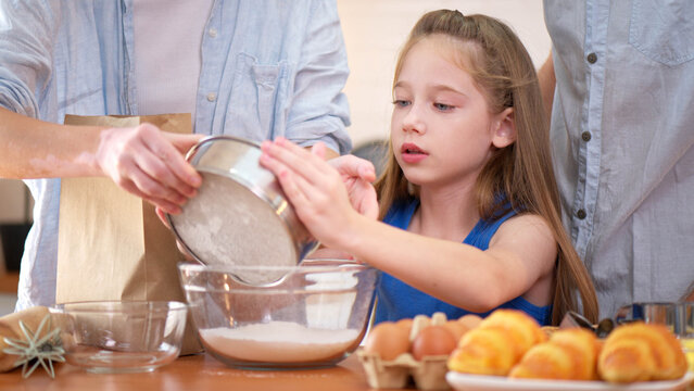 Family bonding moment in the kitchen as parents and daughter bake together