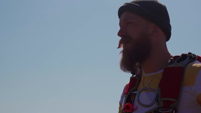 After landing, the skydive smoking a cigarette at a successful jump. Face of a man who enjoys extreme sports, looking for adrenaline, risk, and challenging tasks.