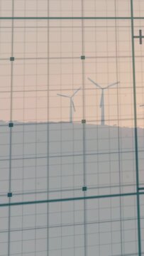 Vertical video: Wind spinning turbines slowly while camera grid nudging frames for composition