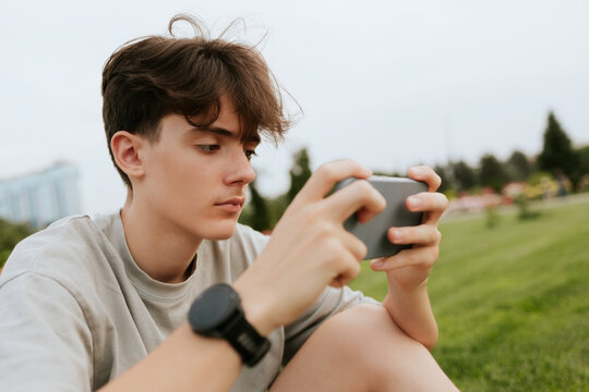 Teenage boy using smartphone in park