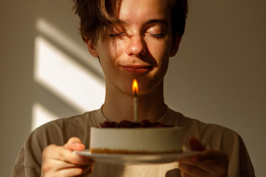 Young person making wish over birthday cake candle