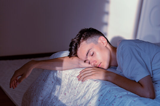 Young man sleeping comfortably on bed