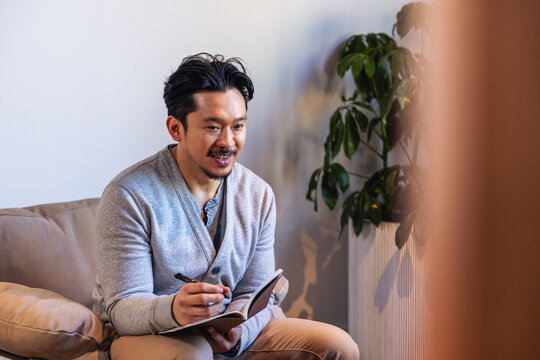 Asian Man sitting with a notebook in a meeting at the office