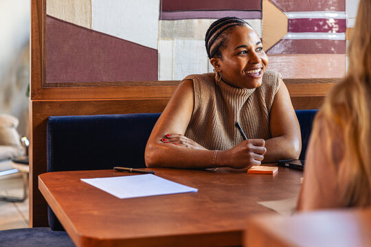Smiling businesswoman in conversation with coworker