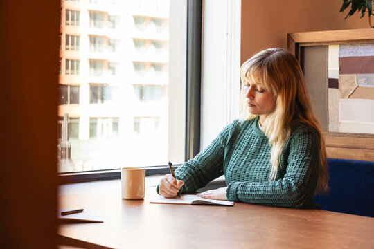 Caucasian woman taking notes at the office
