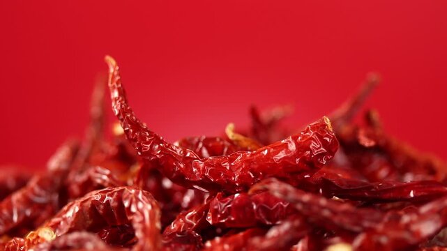 Pile of dried bird chilies rotating  slowly on red background, Thai food ingredient, Close-up shot.