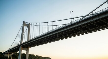 Fototapeta premium Majestic suspension bridge against a gradient sky, showcasing modern engineering and travel connectivity