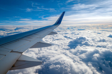 Obraz premium Close up of airplane wing above clouds with bright blue sky, minimal composition, travel concept