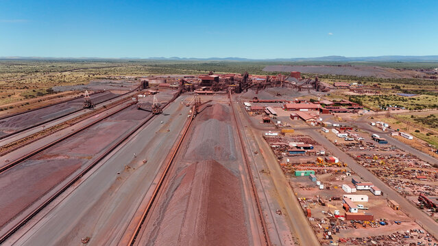 Drone aerial of active mining site with rail infrastructure, stockpiles and industrial processing landscape in South Africa.