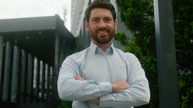Confident pensive Caucasian middle aged businessman standing outside office building adult male employer think pondering turn head looking camera crossed hands posing city employment outdoor daylight