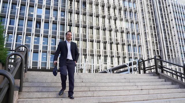Confident businessman walking downstairs outside building