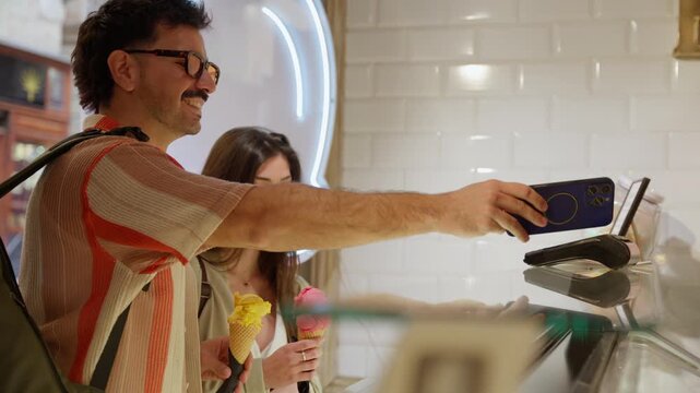 Young man making contactless payment with smartphone