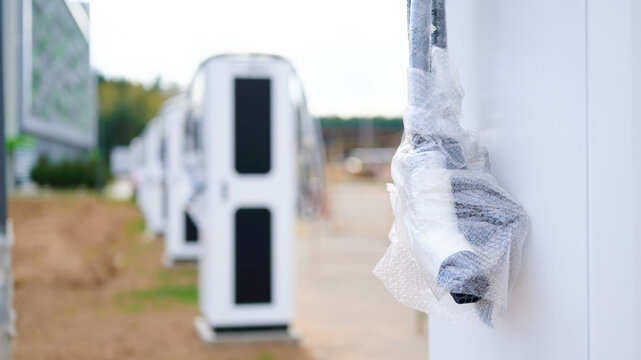 Electric vehicle charging cable wrapped in bubble wrap at outdoor charging station.
