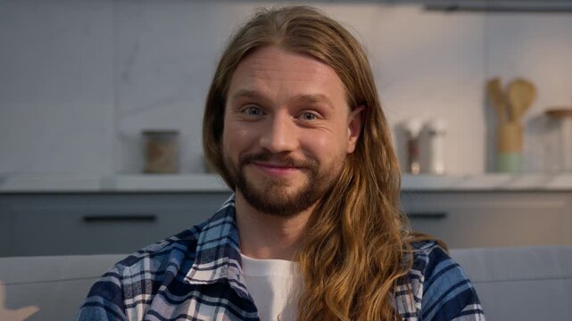 Serious concentrated Caucasian man watching TV at home apartment male focused frowning surprised amazing news reaction smiling unexpected joy guy enjoying movie film indoors facial expression emotion