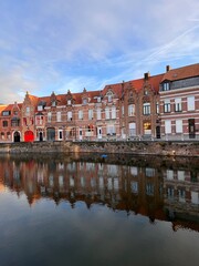 Obraz premium Picturesque row of medieval houses reflecting in the canal water in Bruges, Belgium