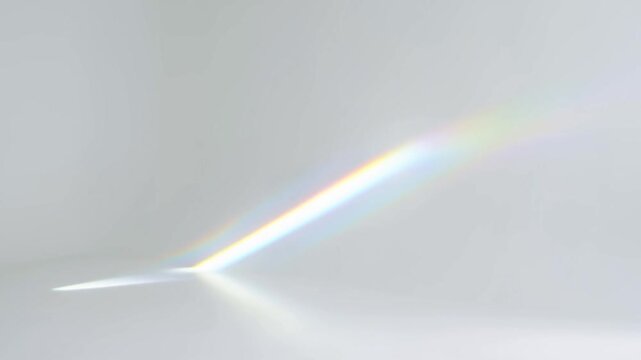 Slow motion static shot of prism light streak shifting across white interior wall with rainbow beam and soft diffuse reflections in minimal room setting