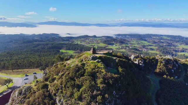 4K Drone shot of Pico Sacro peak near Santiago de Compostela. Panoramic views of the Ulla River valley, green Galician landscape, and the legendary "Calle de la Reina" rock formation under a clear sky