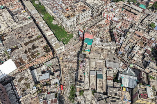 Keraniganj, Bangladesh - 11 April 2026: Aerial view of a sprawling urban tapestry where a narrow ribbon of green cuts through a dense mosaic of weathered concrete and brick.