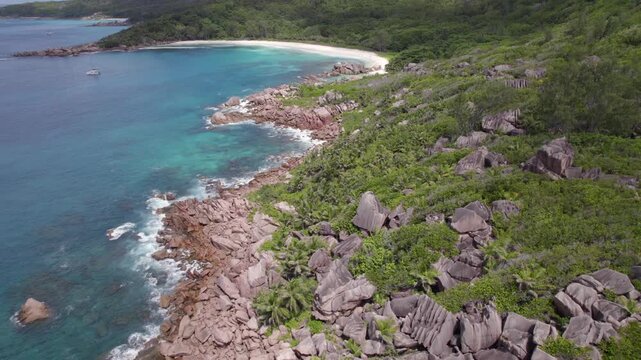 Drone of granites stones, clear turquoise water, untouched nature, white sandy beach, docked catamaran, anse cocos, La Digue, Seychelles 013