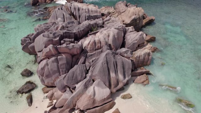 Bird eye view drone of huge granites stones near shoreline, clear turquoise water, people snorkelling, anse cocos, La Digue, Seychelles 001