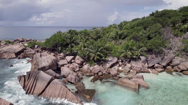 Drone of amazing nature from grand anse beach, granite stones, crushing waves, untouched nature, La Digue, Seychelles 30fps 007