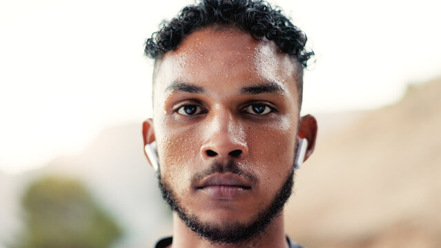 Portrait, man and earphones outdoor with exercise break, sweating and training recovery for wellness. Space, serious person and athlete with cardio workout rest, fitness and audio tech for music.