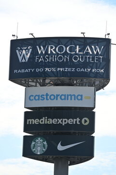 Shopping outlet pylon with multiple retail brand logos in Wroclaw
