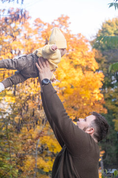 Portrait of Father and Baby Enjoying Autumn in the Park